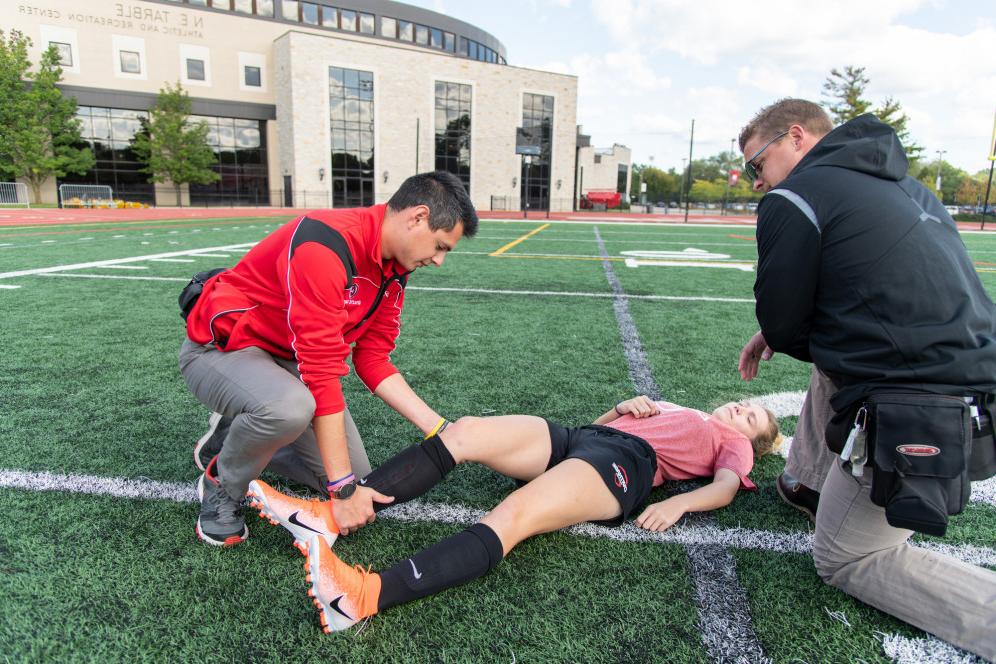 An athletic training student practices on a fellow student.